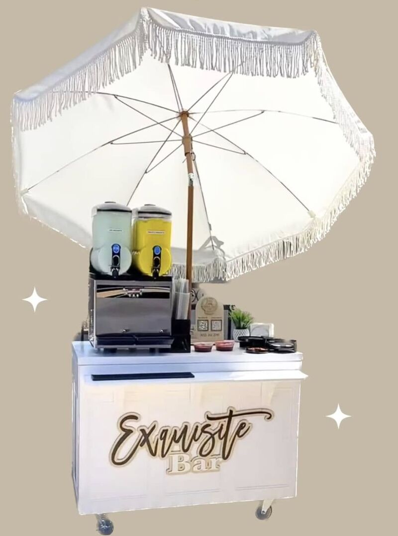 The Exquisite Bar: a white cart with a two-bowl frozen drink machine under a fringed umbrella