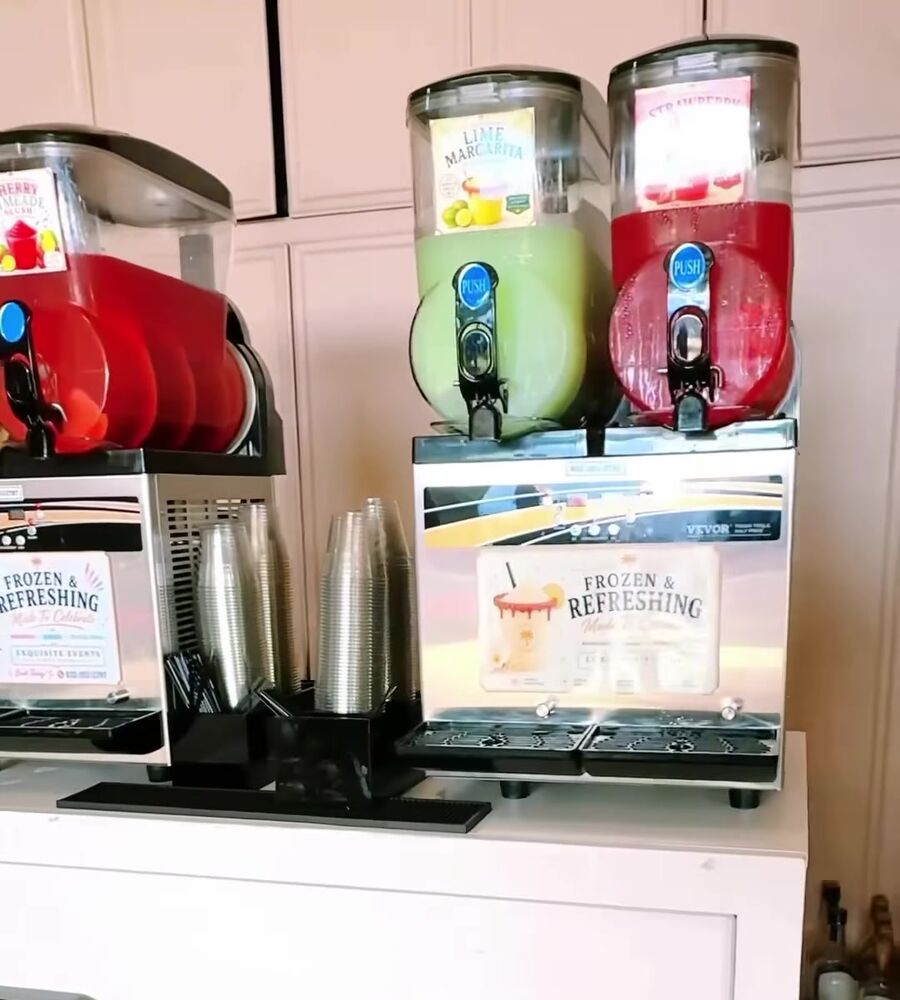 Frozen drink machines set up on a white bar cart