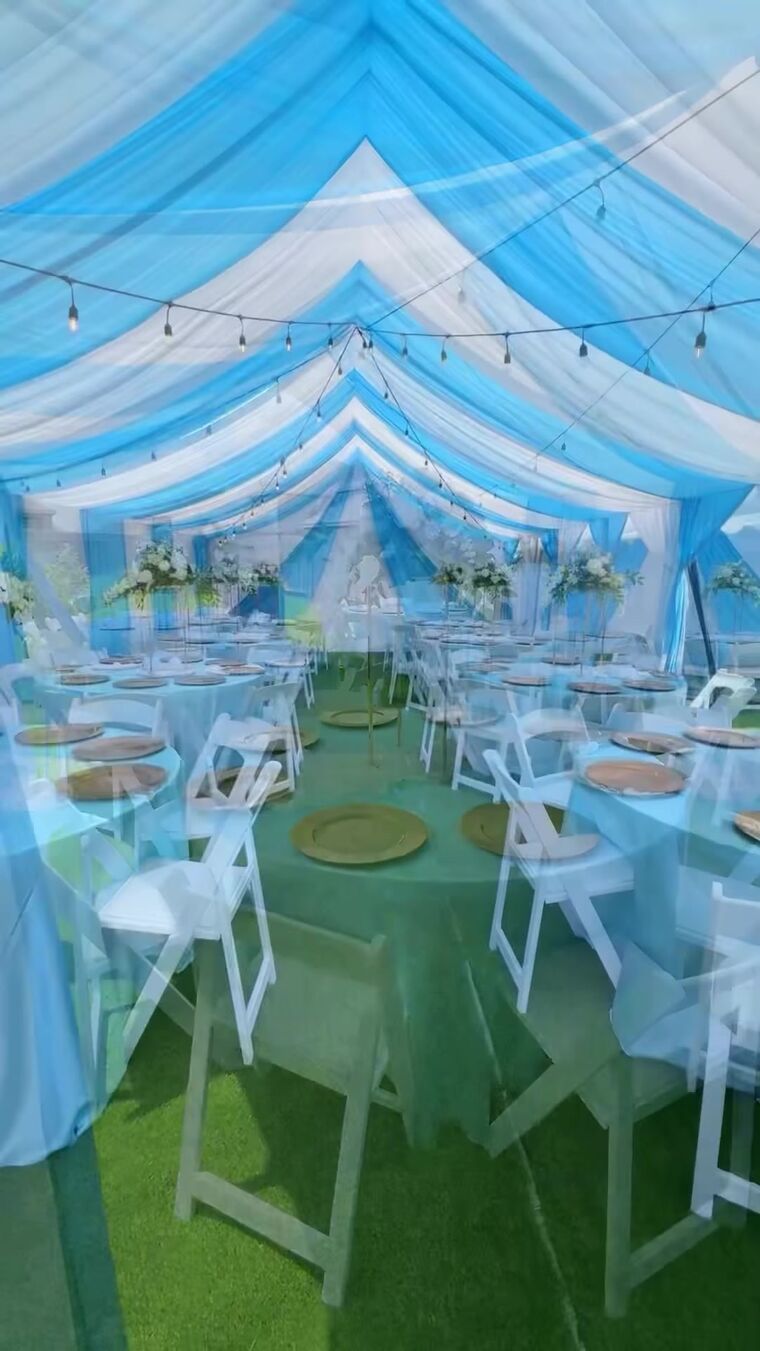 Looking down the center of a tent draped in blue and white