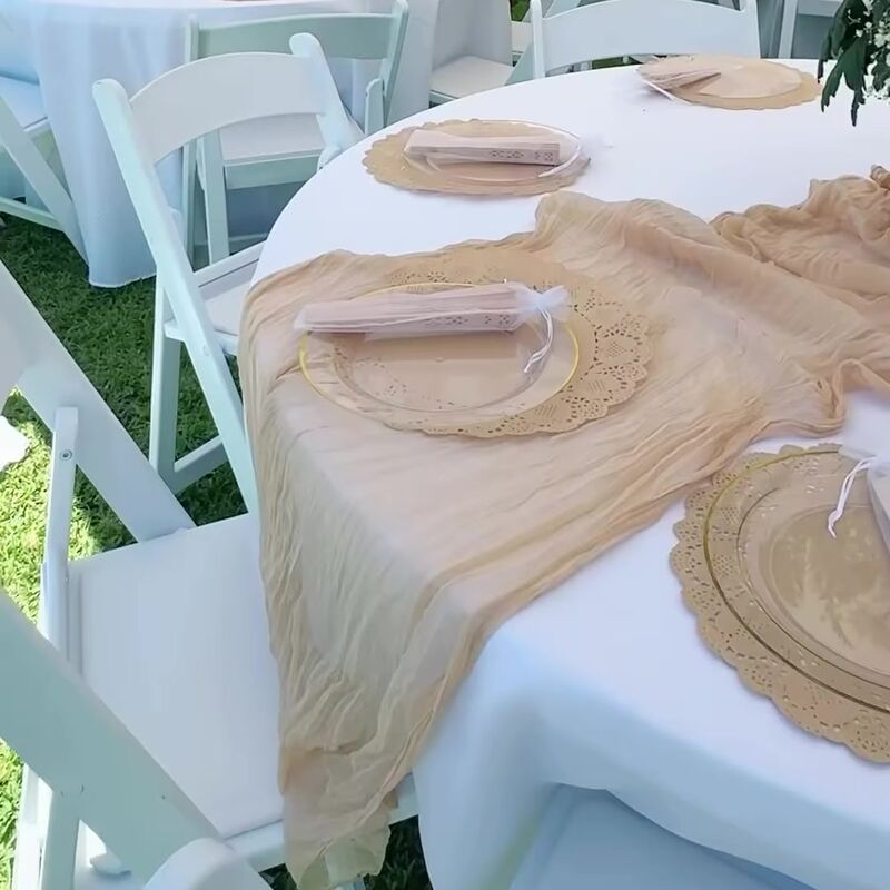 Round table with a lace runner and gold place settings