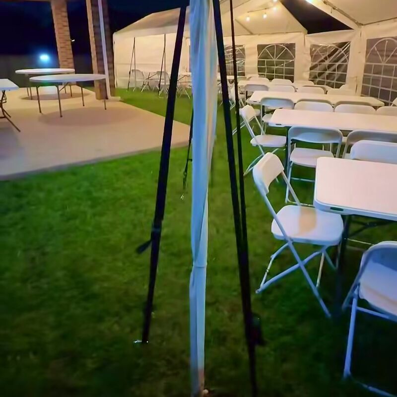 Tents with window walls, tables and chairs set up at night