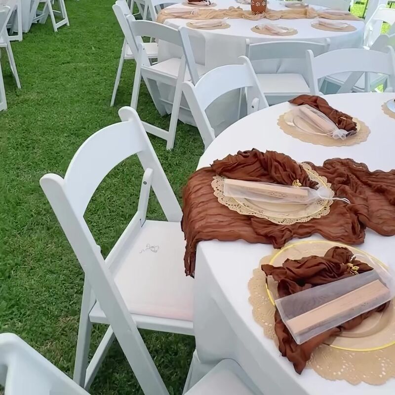 Round table with a rust runner, lace placemats and a flower centerpiece